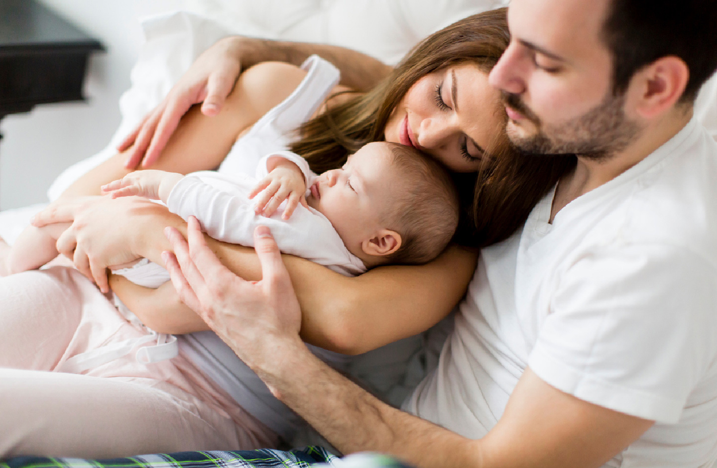 Eltern kuscheln glücklich mit ihrem Baby