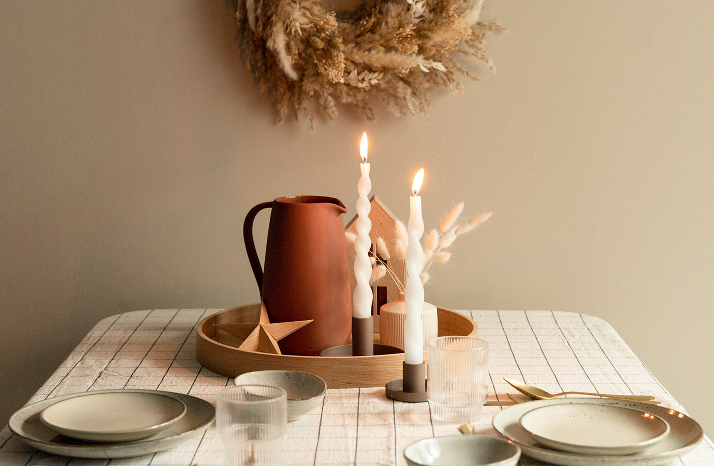 Eingedrehte Stabkerzen festlich dekoriert im Kerzenständer auf einer weihnachtlichen Festtafel.