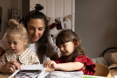 Eine Familie schaut sich einen Fotokalender an.