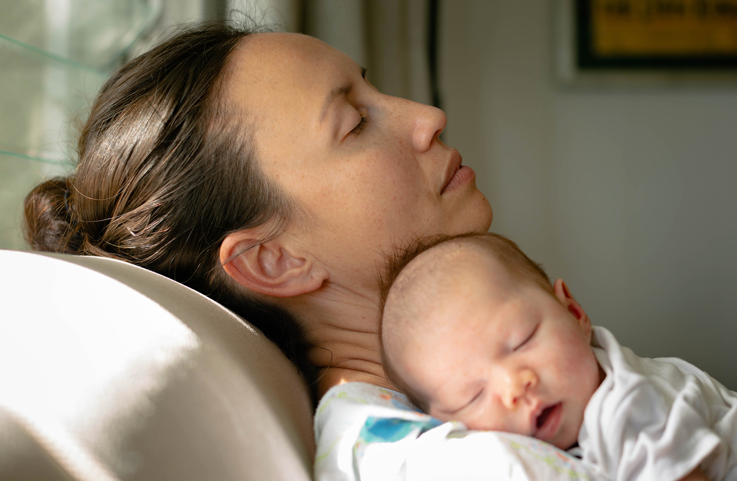 Erschöpfte Mutter mit schlafendem Baby  entspannt mit geschlossenen Augen