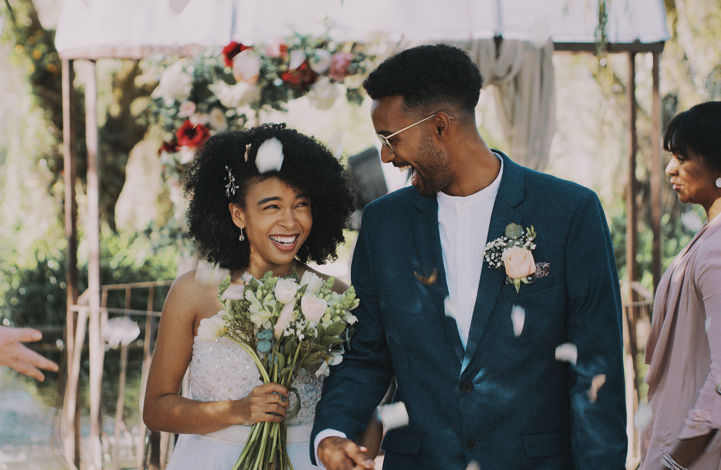 Hochzeitspaar wird nach der Trauungzeremonie mit weißen Blüten beworfen und feiert ohne Hochzeitstauben.