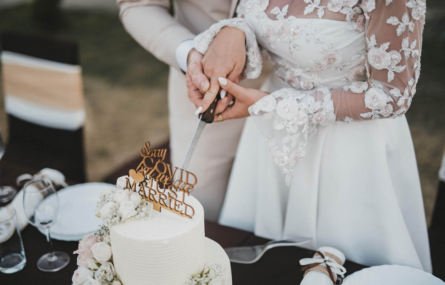 Brautpaar küsst sich beim Anschneiden der Hochzeitstorte