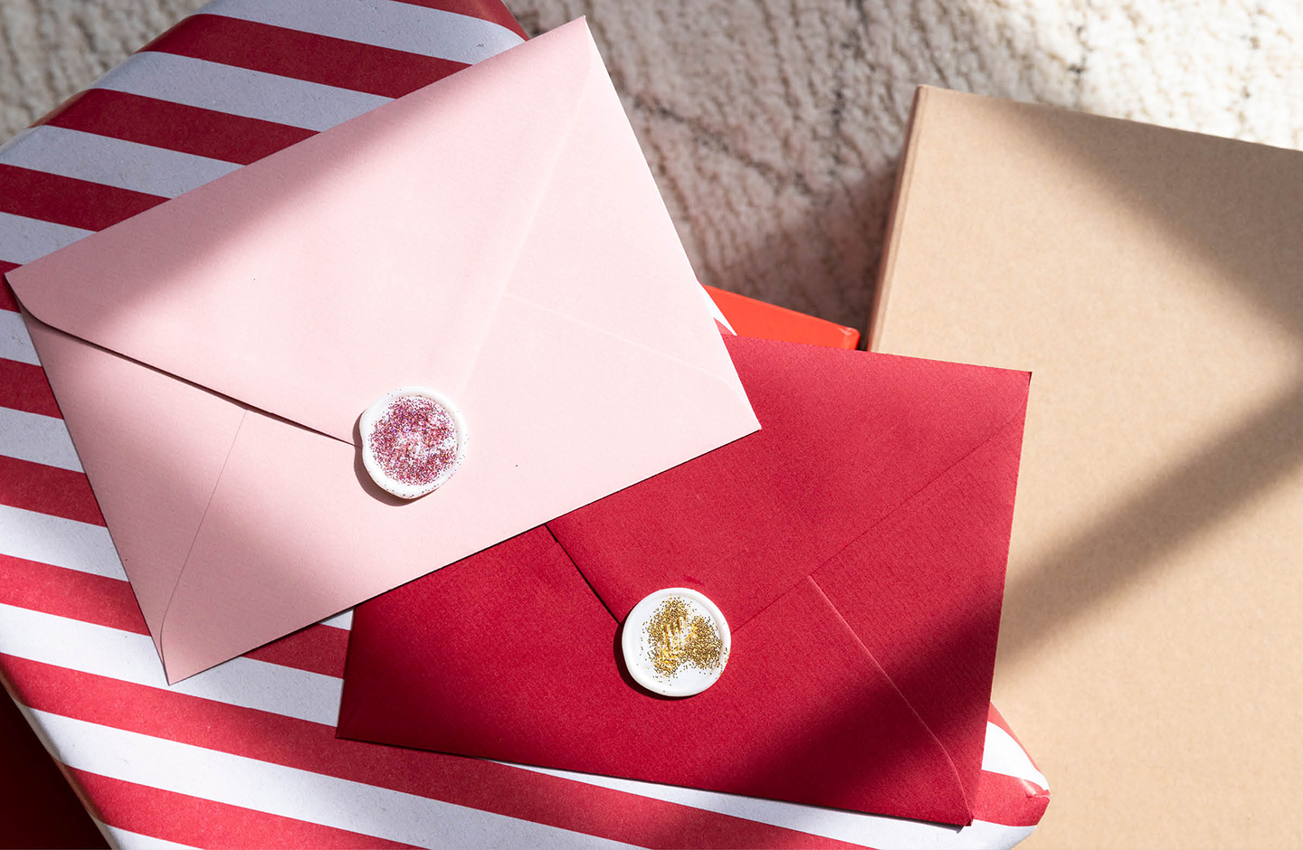 Briefumschlag in rosa und rot versiegelt mit einem glitzernden Wachssiegel.