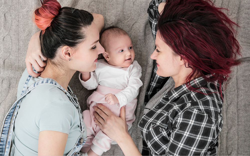 Zwei Frauen kuscheln mit Baby