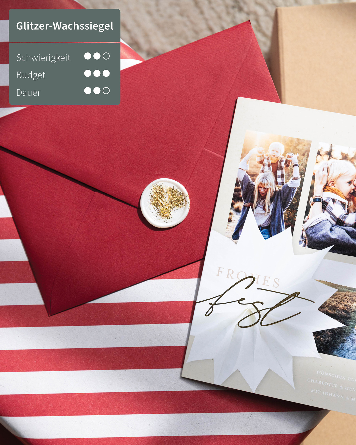 Weihnachtskarte liegt neben Briefumschlag auf dem Tisch. Der Umschlag ist mit einem Glitzer-Siegel verschlossen.