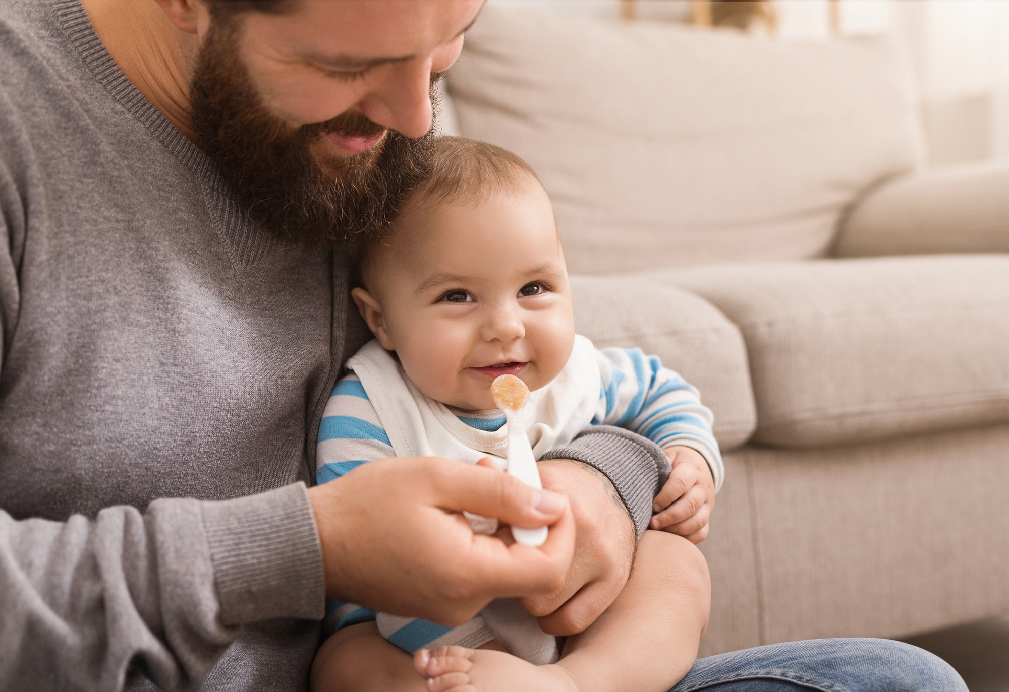 Vater füttert Baby