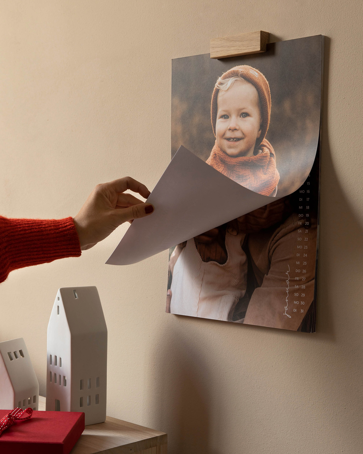 Kalender hängt an der Wand. Hand blättert Kalender um.