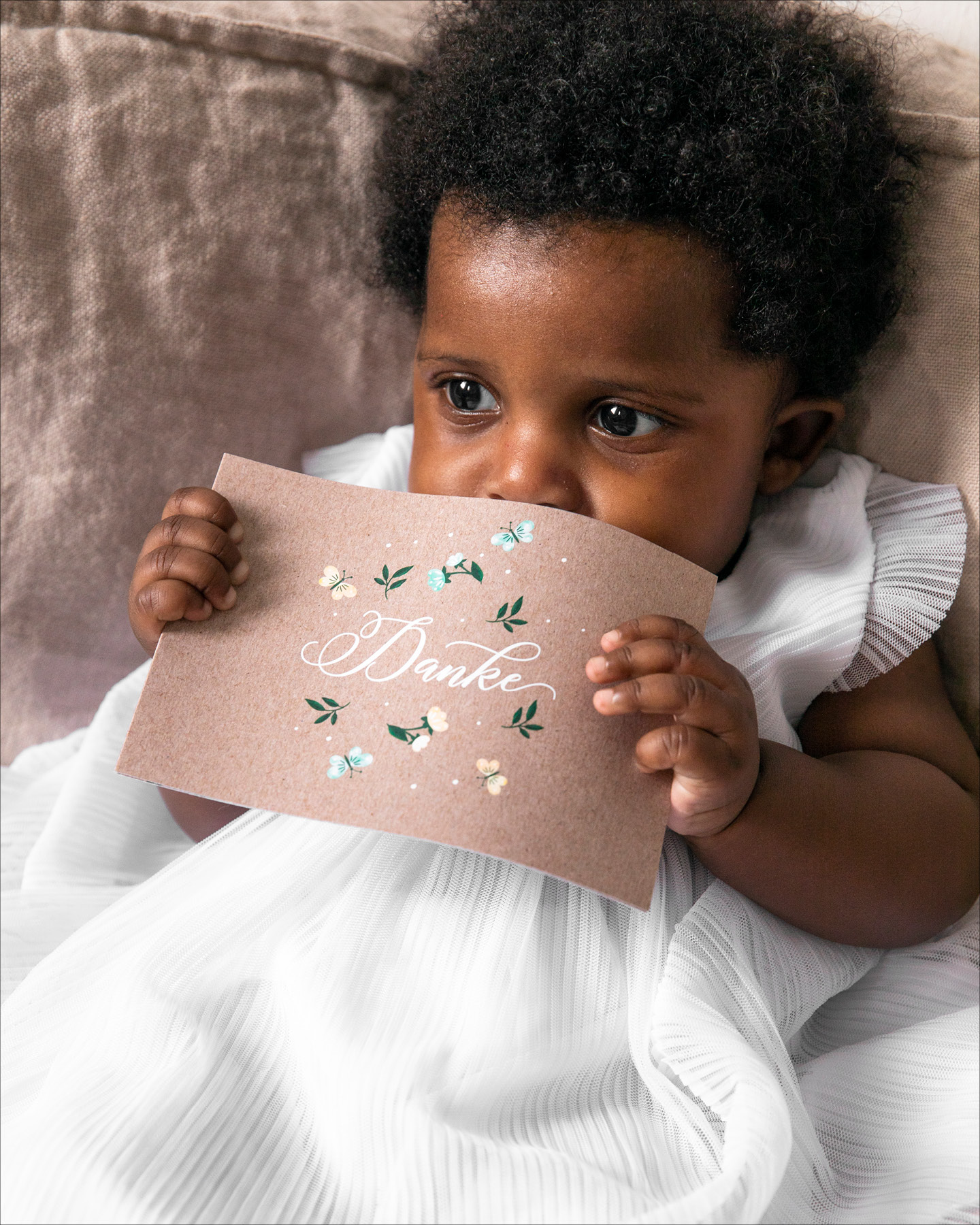 Kleines Mädchen im weißen Kleid hält deine Dankeskarte zur Willkommensfeier in den Händen