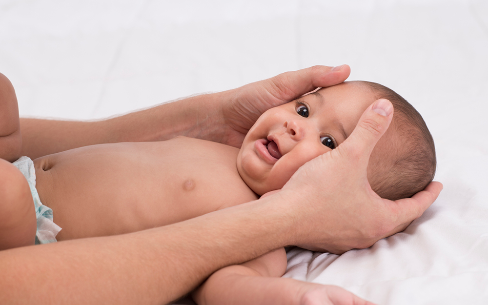 Mutter massiert Gesicht des Babys