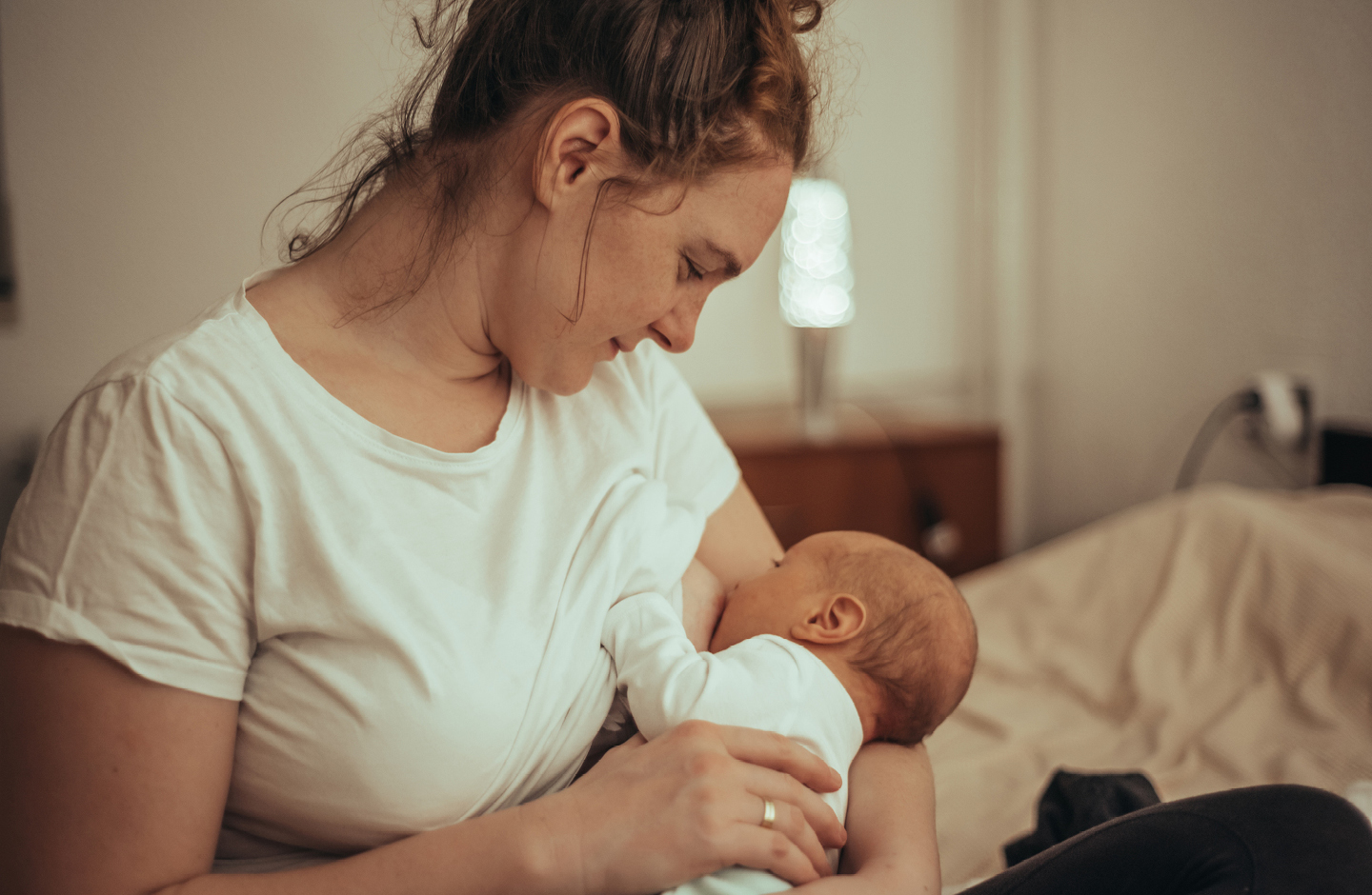 Stillende Mutter hält Baby im Arm