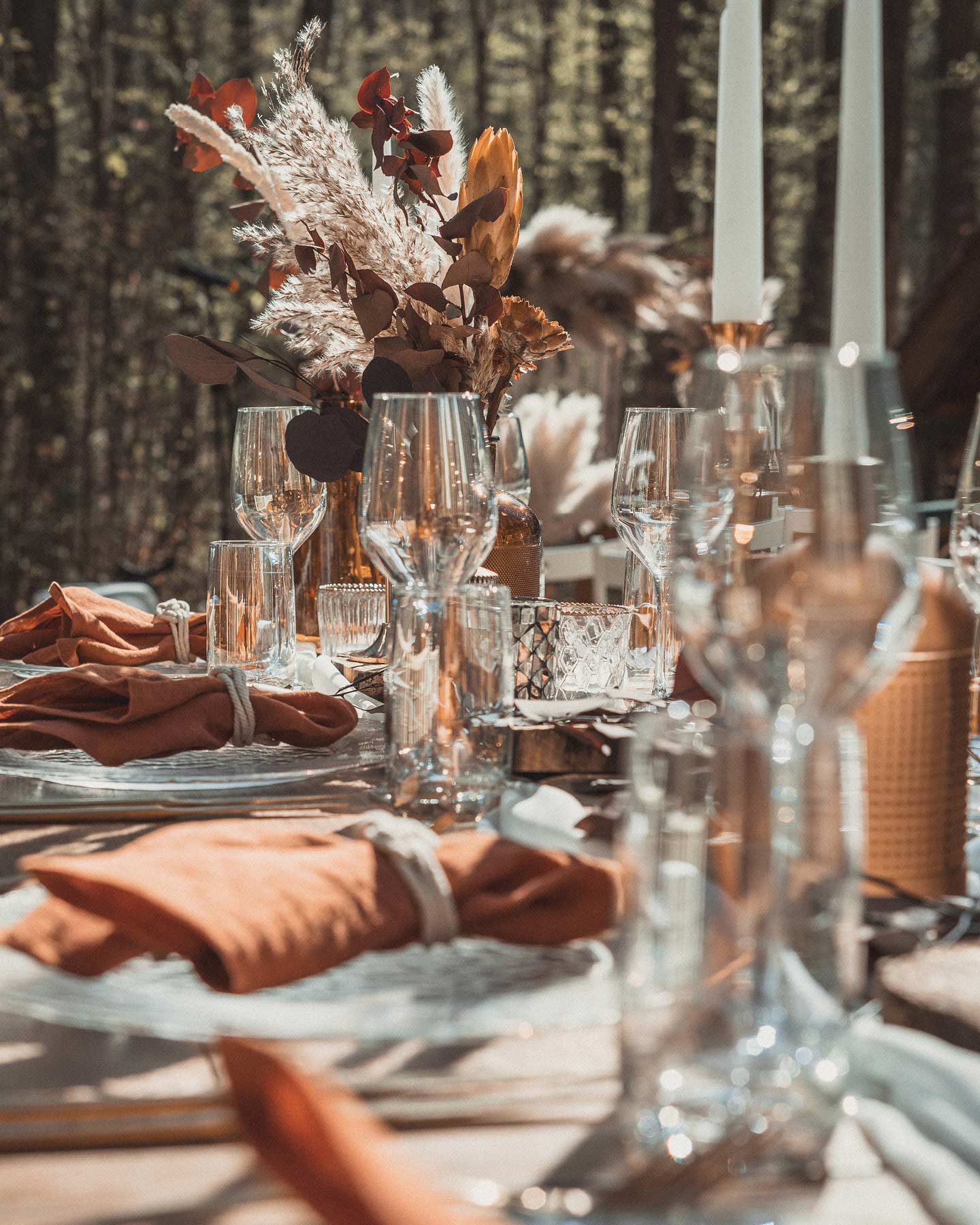 Hochzeitstafel im Boho Vintage Look ist in Erdtönen mit Holz und Glas dekoriert.