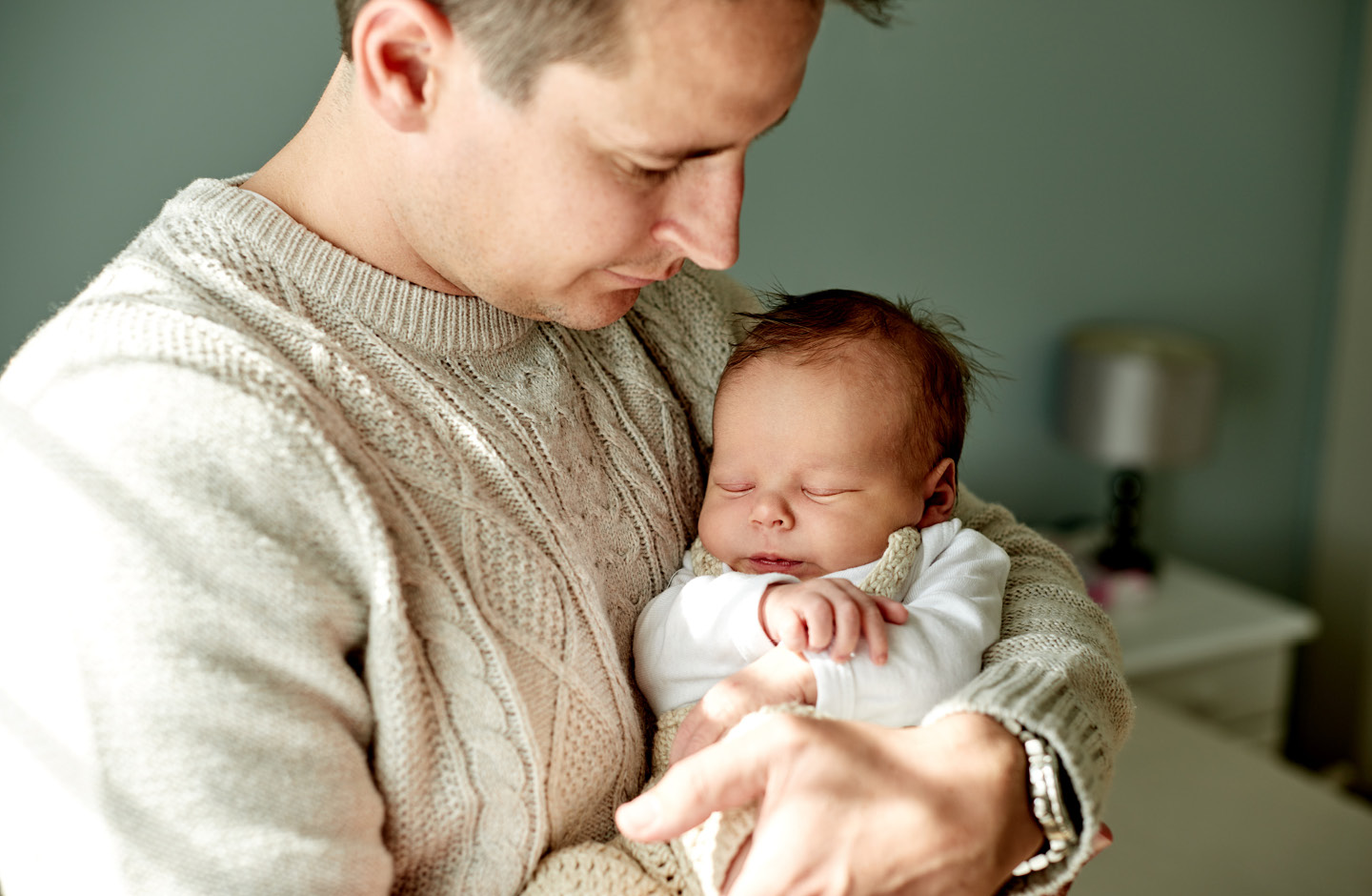 Vater hält sein schlafendes Baby im Arm