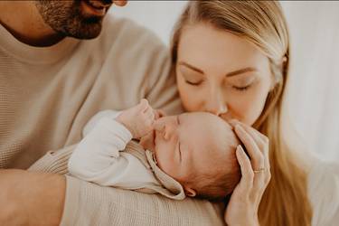 Glückliche Eltern im Wochenbett mit neugeborenem Baby