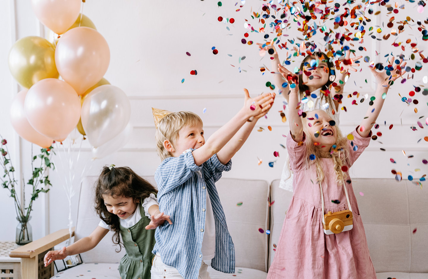  Kinder spielen an Geburtstag mit Konfetti