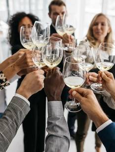 Arbeitskolleg:innen stoßen mit Wein an.