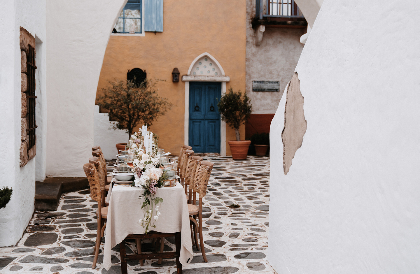 Hochzeitstisch steht in italienischer Kullise und ist im Boho Greenery Look dekoriert.