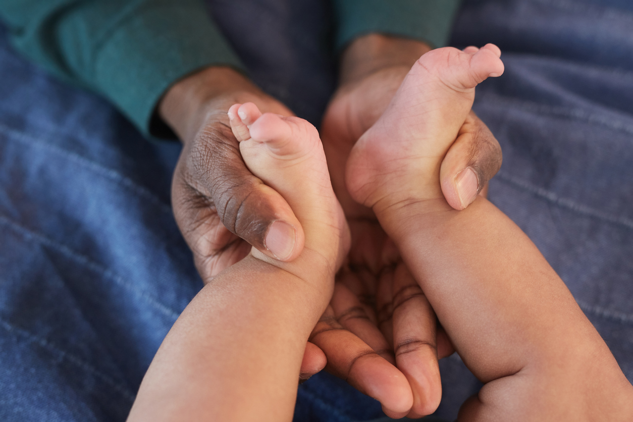 Glücklicher Papa hält die Füßchen seiner kleinen Tochter mit arabischem Mädchennamen