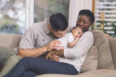 Glückliche Eltern betrachten ihr Baby mit spanischem Mädchennamen