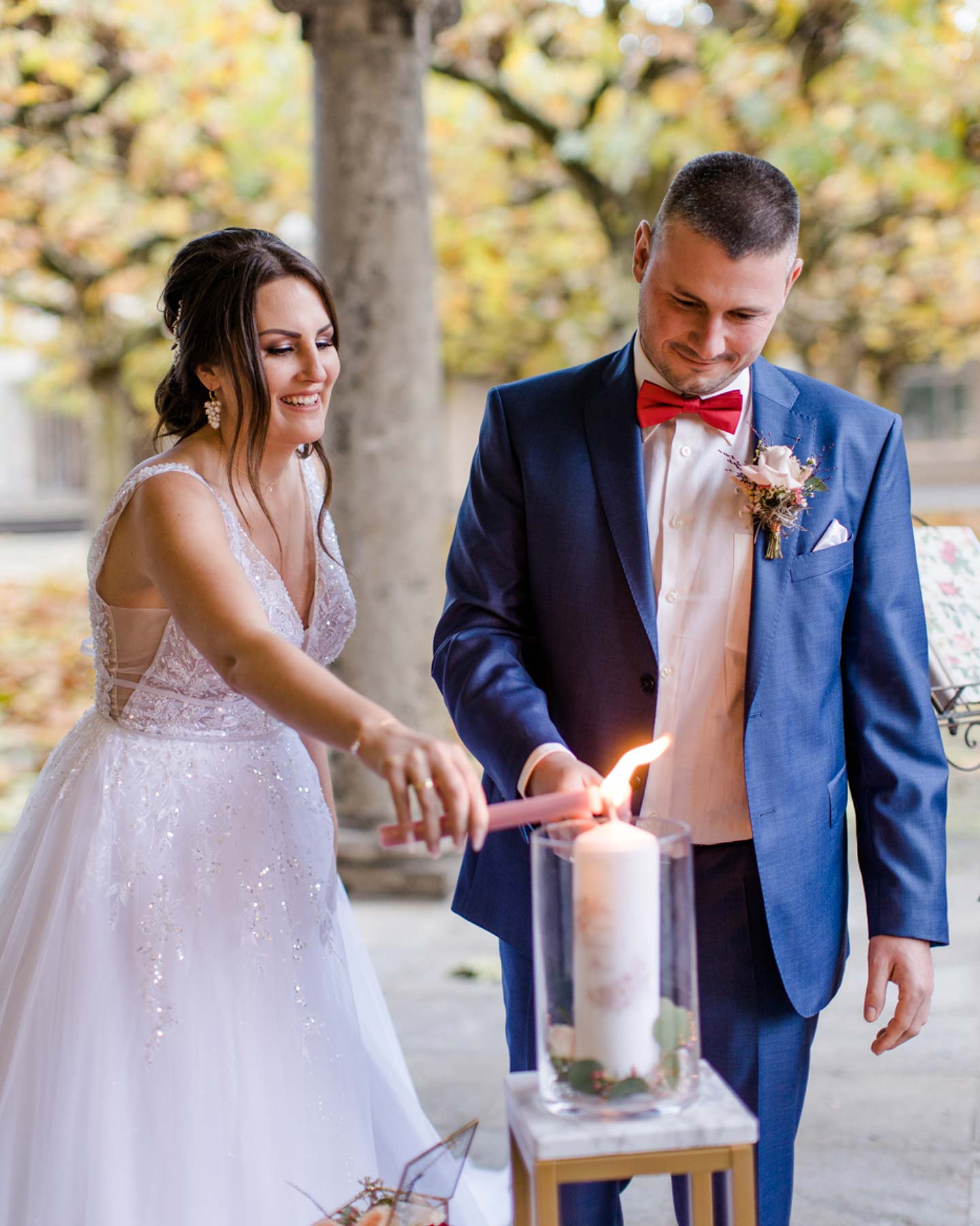 Brautpaar zündet gemeinsam die Hochzeitskerze an.