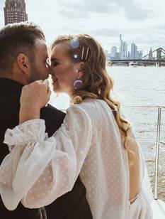 Hochzeitspaar in zärtlicher Pose in einem Boot auf dem Main 