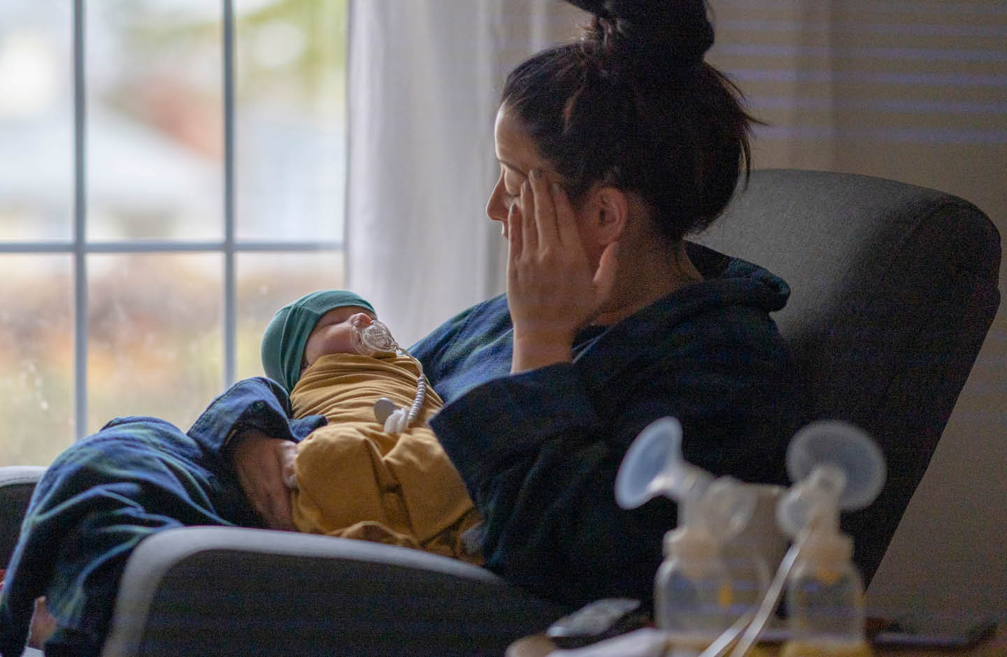 Frau mit Baby auf dem Arm im Wochenbett