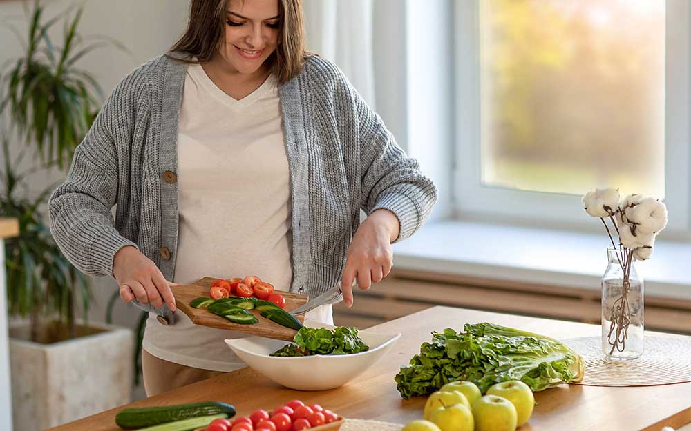 Schwangere kocht frisches Essen