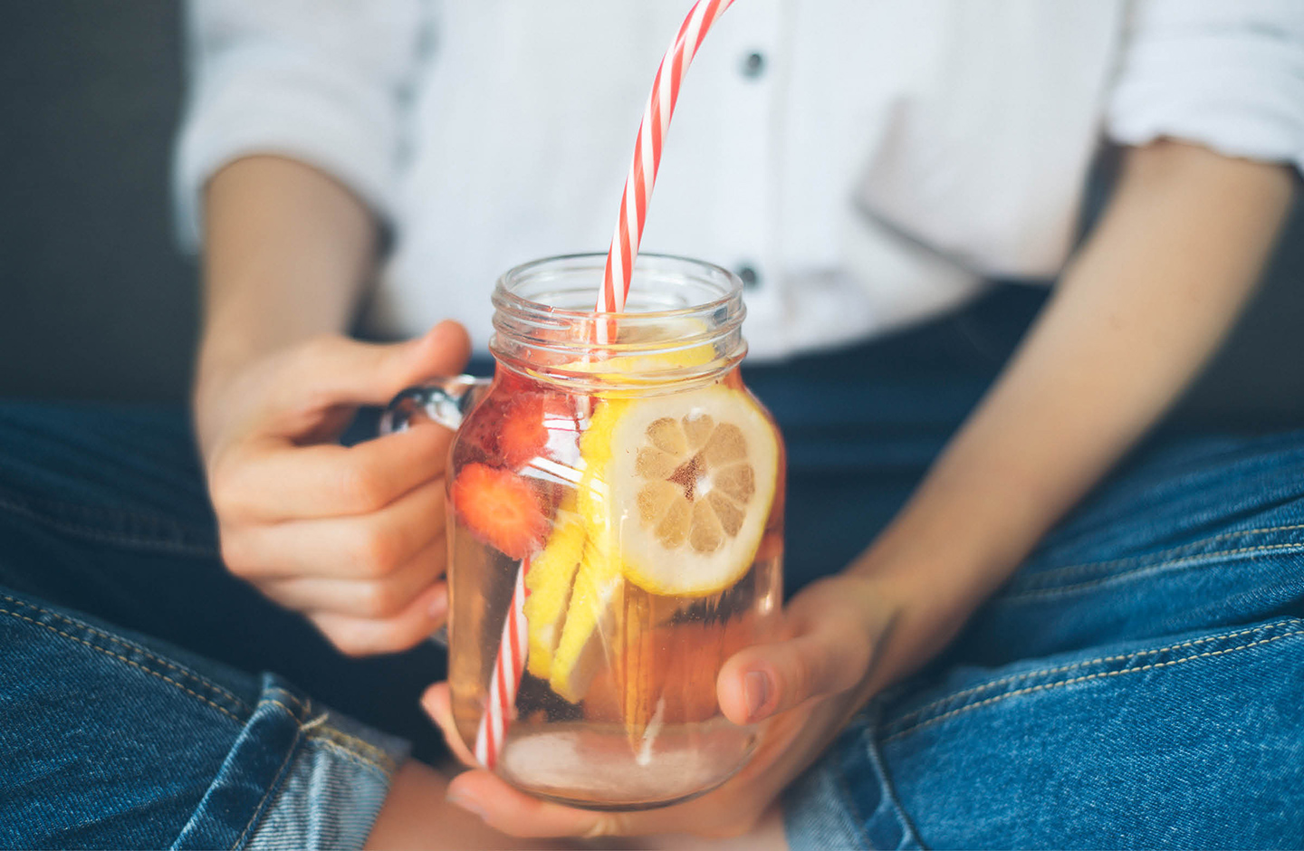 Frau hält Limonaden Glas in der Hand.