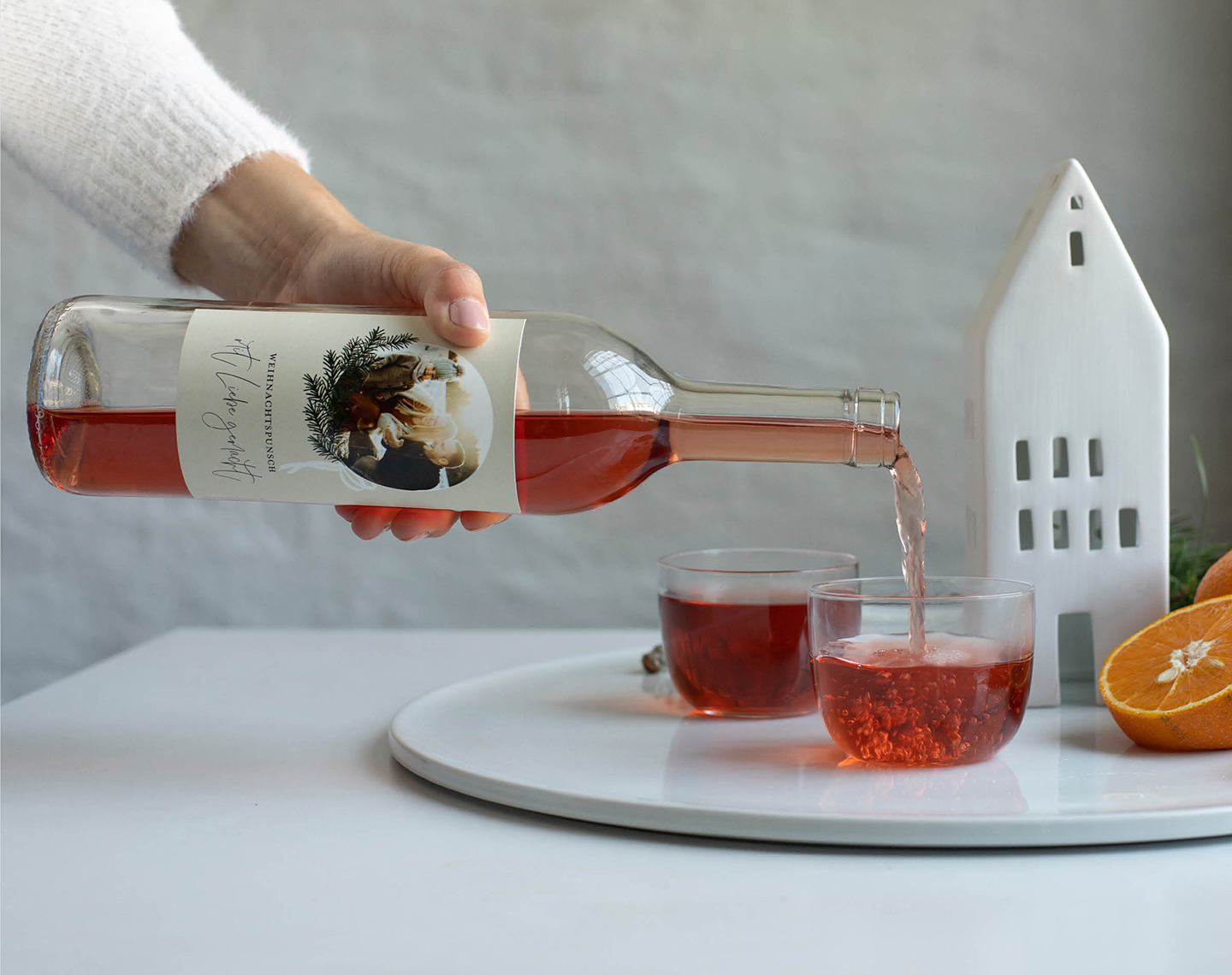 Weihnachtspunsch wird in Glas geschenkt. 