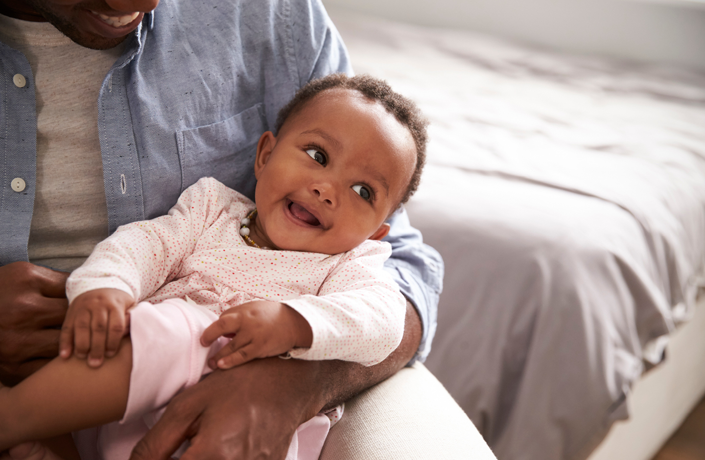 Baby mit französischem Mädchennamen auf weißer Strickdecke mit Lochmuster