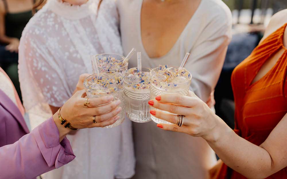 Hochzeitspaar stößt mit Freund:innen auf die Hochzeit an