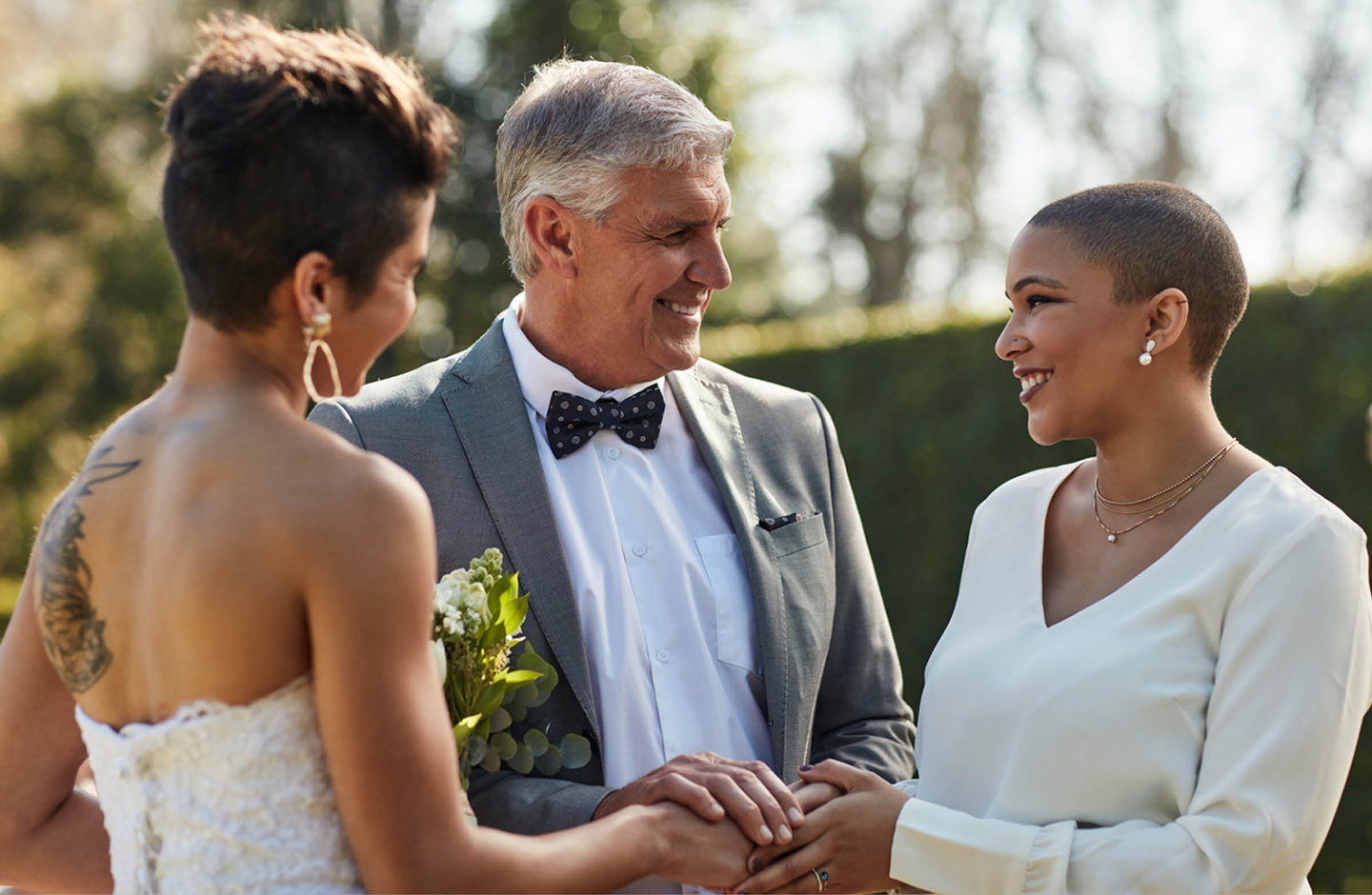 Hochzeit zweier Frauen, die vom Vater der einen Ehepartnerin ihren Segen bekommen.