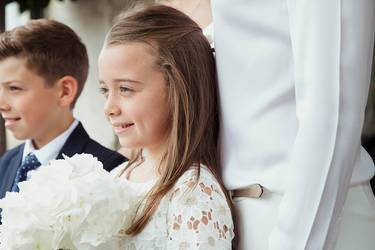 Bruder und Schwester stehen nebeneinander. Sie sind anlässlich einer Hochzeit festlich gekleidet.